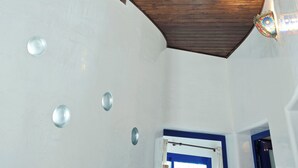 A room with a sloped ceiling, wooden paneling, and a white wall with a door.