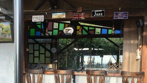 A rustic bar area with wooden stools and a wooden counter. There are signs indicating music genres like Jazz and events like New Orleans Jazz. - hotel san mateo  (Nobsa)