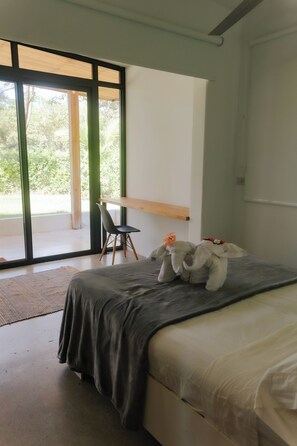 Un dormitorio con una cama, una silla y un escritorio.