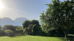 A grassy outdoor area with trees and mountains in the background. - Vacation Apartment by Lake Annecy in Sevrier (Sevrier)