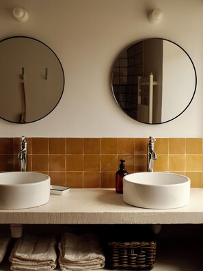 Un bagno con due lavandini, uno specchio e un porta asciugamani.