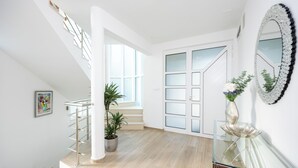 A modern interior with a staircase, a glass table, and a large mirror. - Breathtaking villa W Seaview & heated pool (Kučine)