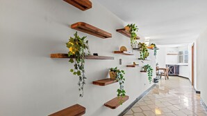 Un passadís amb prestatgeries de fusta que sostenen plantes i un paviment de rajoles.