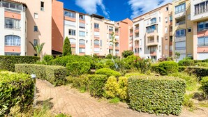A residential building with multiple balconies, a paved pathway, and well-maintained greenery. - Apartment 'Sur Le Port' with Sea View and Private Garden (Agde)