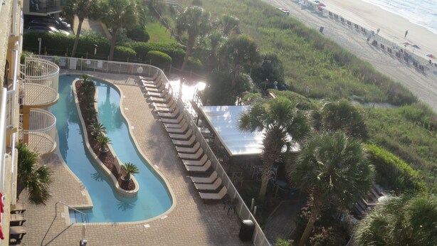 A pool area with lounge chairs, a small pool, and a view of the beach. - N.Myrtle Beach Oceanfront 2BR, July 20-27 Shorecrest Vacation Villas I resort (North Myrtle Beach)