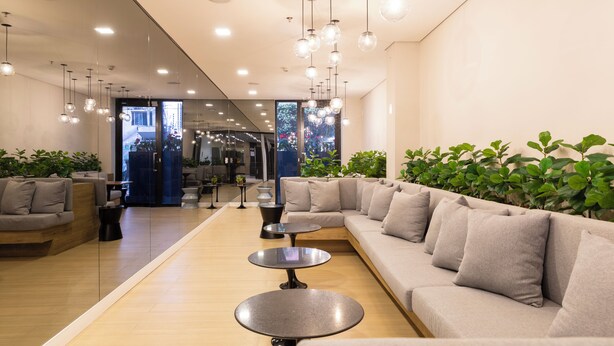 A modern lounge area with a sofa, round tables, hanging lights, and potted plants. - Vila Mariana perto do metrô AC (Sao Paulo)
