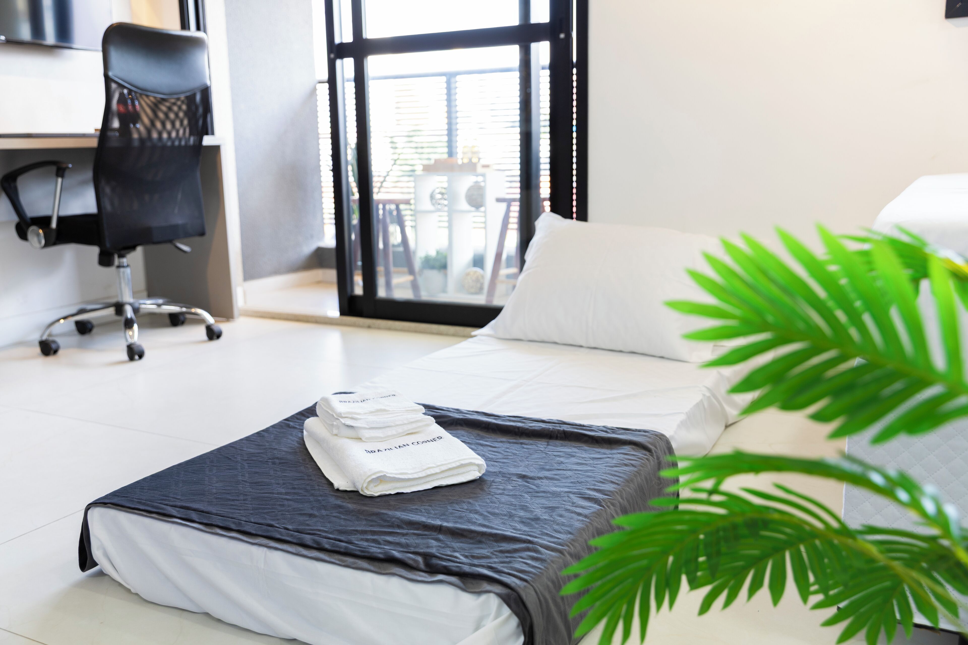 A hotel room with a bed, a desk, and a chair.