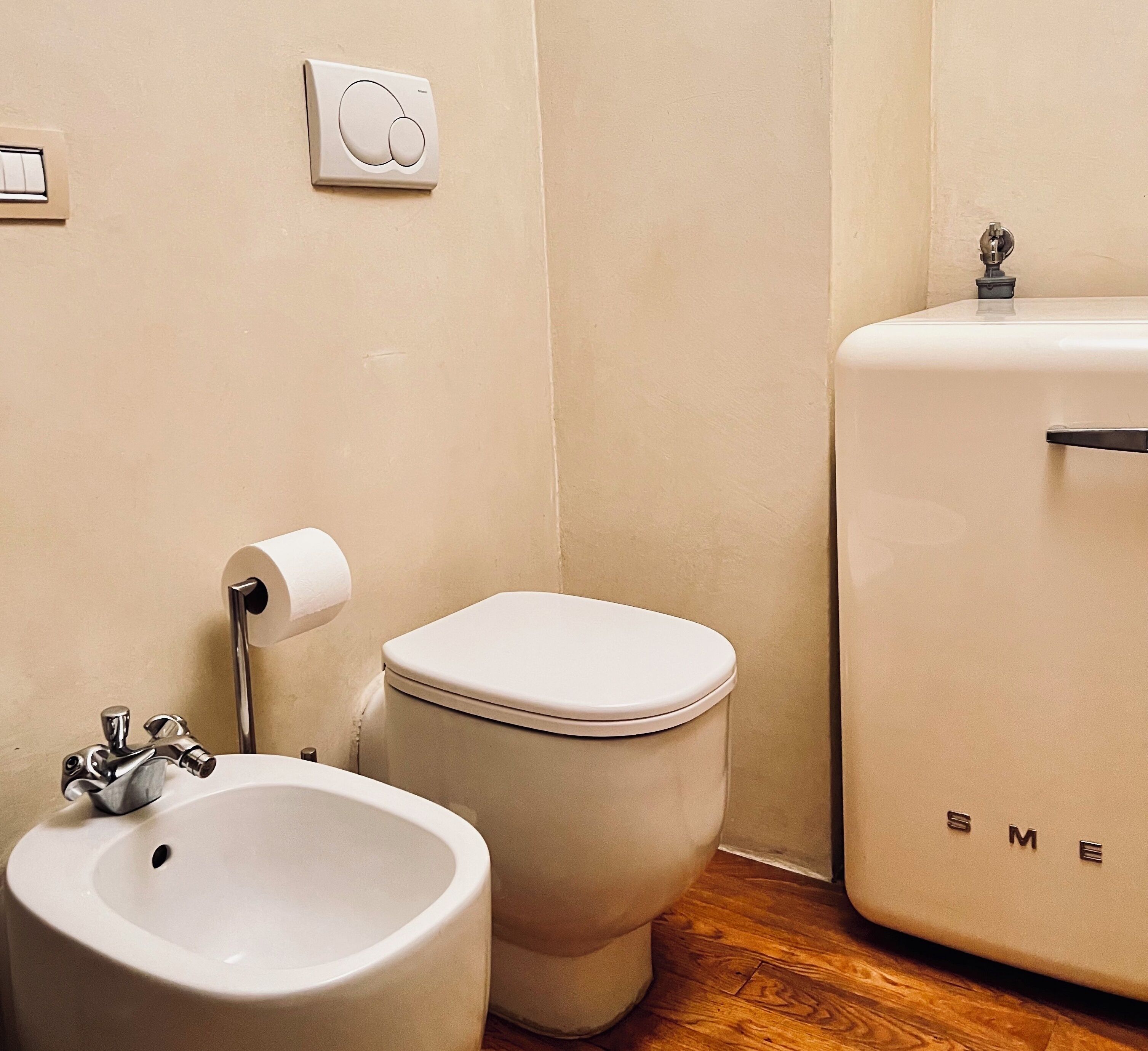 Une salle de bain équipée de toilettes, d’un bidet et d’un lavabo.