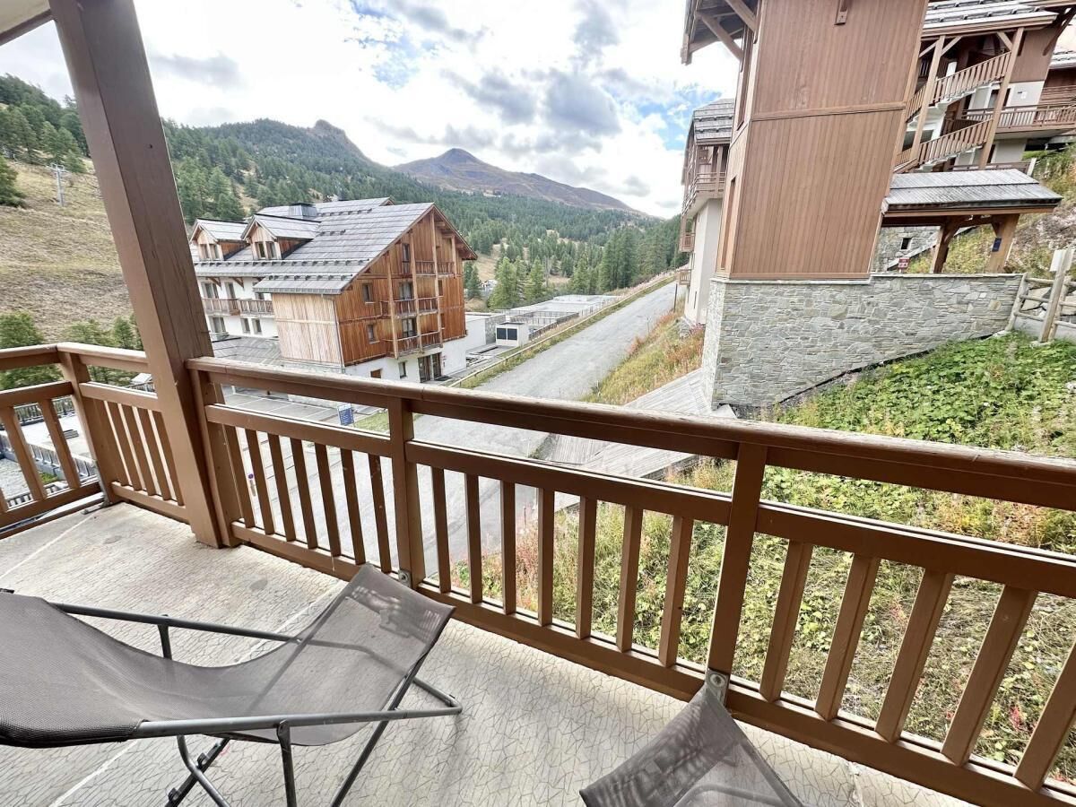 Un balcon avec vue sur une montagne et des bâtiments.
