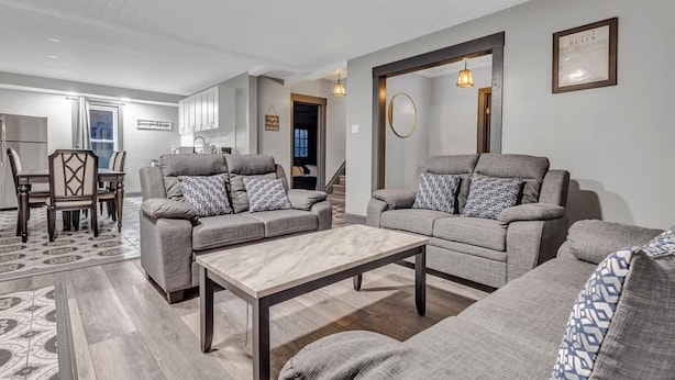 A modern living room with grey sofas, a wooden coffee table, and patterned throw pillows.