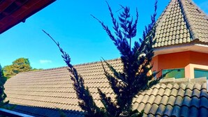A building with a tiled roof and a conical structure. - Gueshouse di Paolo by Concavus (Campos do Jordão)