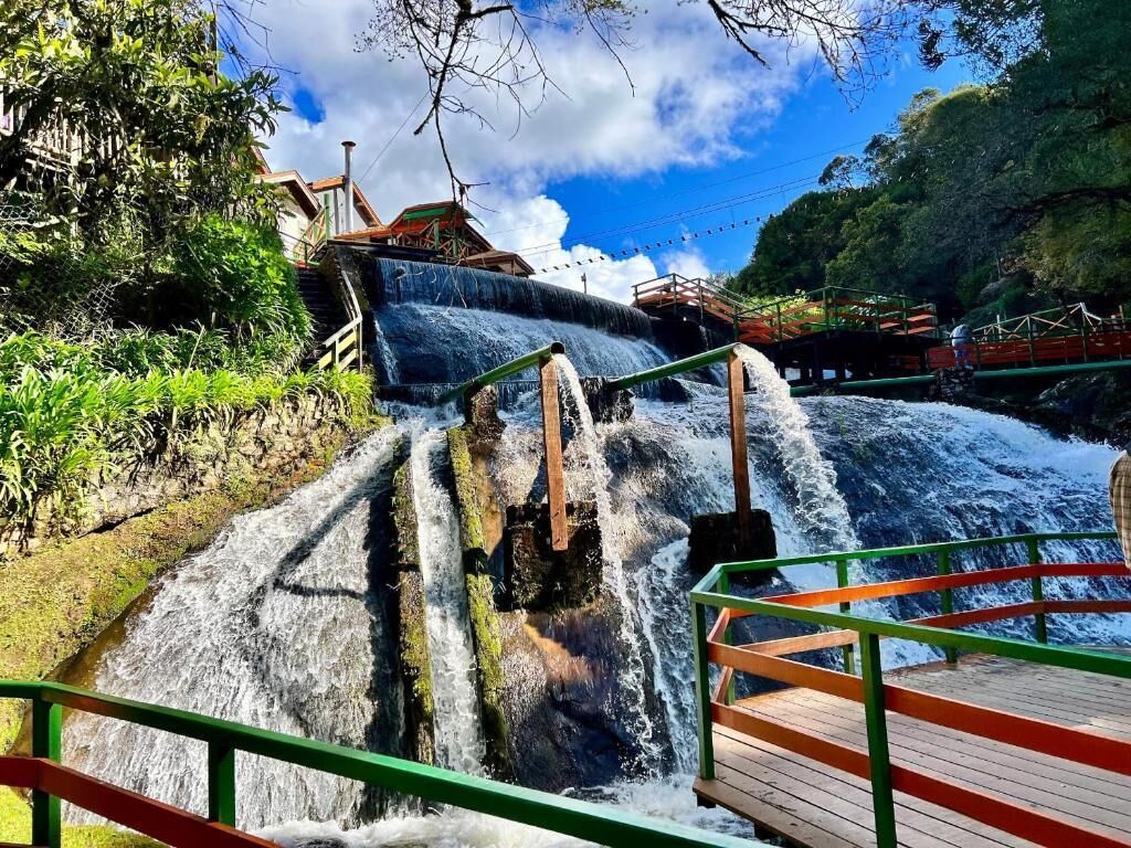 Uma cascata com uma passarela e guarda-corpo de madeira.