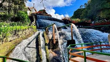 Uma cascata com uma passarela e guarda-corpo de madeira.