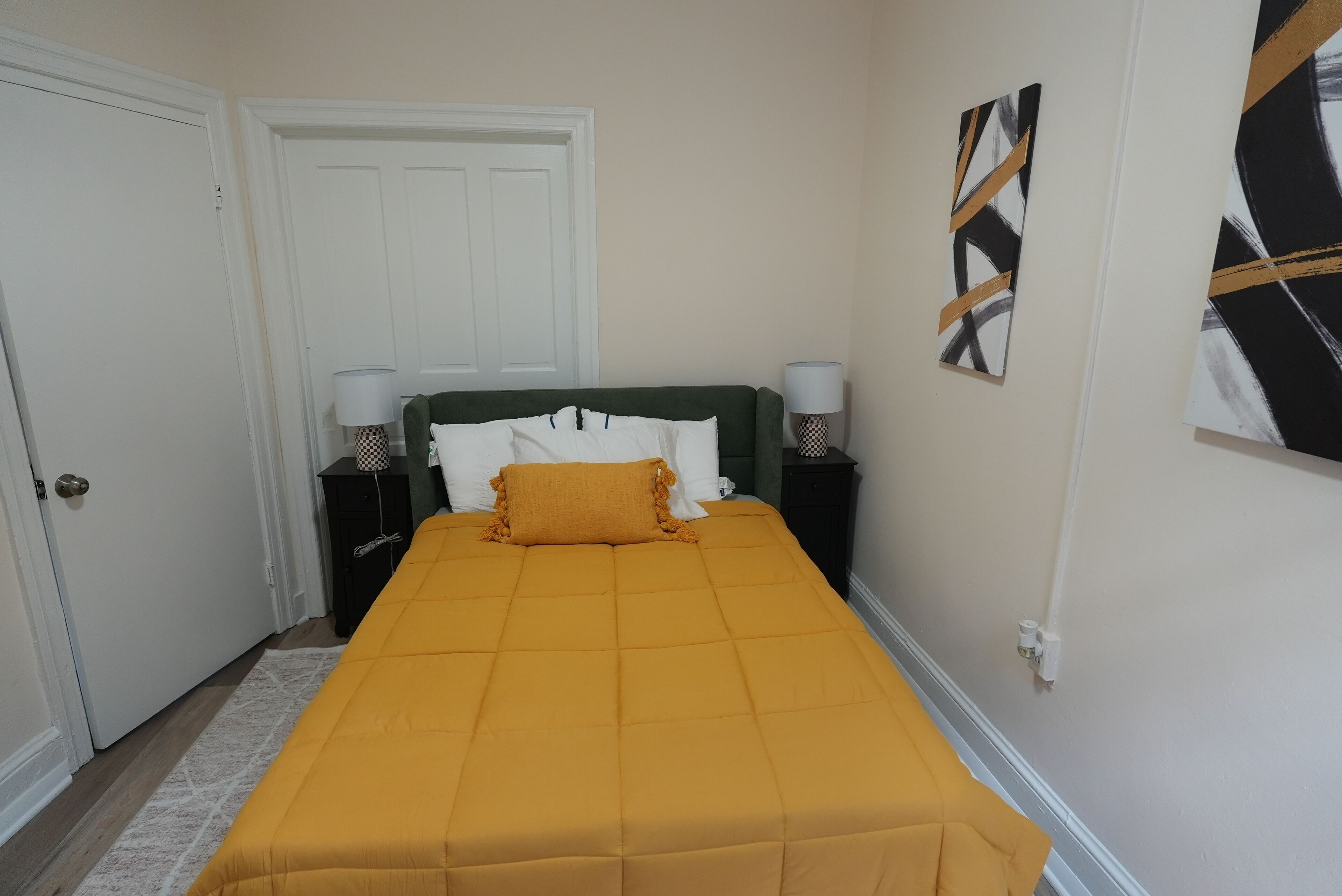 A neatly arranged bedroom with a bed, two bedside tables, and a door.