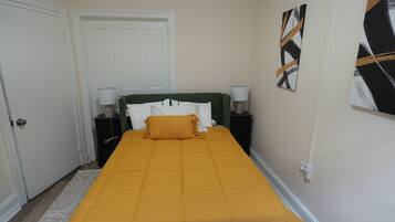 A neatly arranged bedroom with a bed, two bedside tables, and a door.