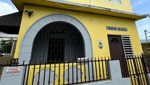 A yellow building with a large arched entrance and a small window above the door.