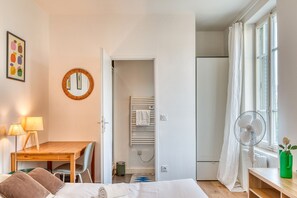Makuuhuoneessa on sänky, yöpöytä, lamppu ja näkymä kylpyhuoneeseen.