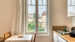 A kitchen with a window, a wooden table, and a chair.