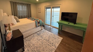 A bedroom with a bed, a TV, a desk, and a window with a view of the water. - Lake Front House with Private Dock and boat rental available!  Lake Eufala (Checotah)