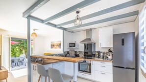 A modern kitchen with a central island, built-in appliances, and a view to an outdoor patio.