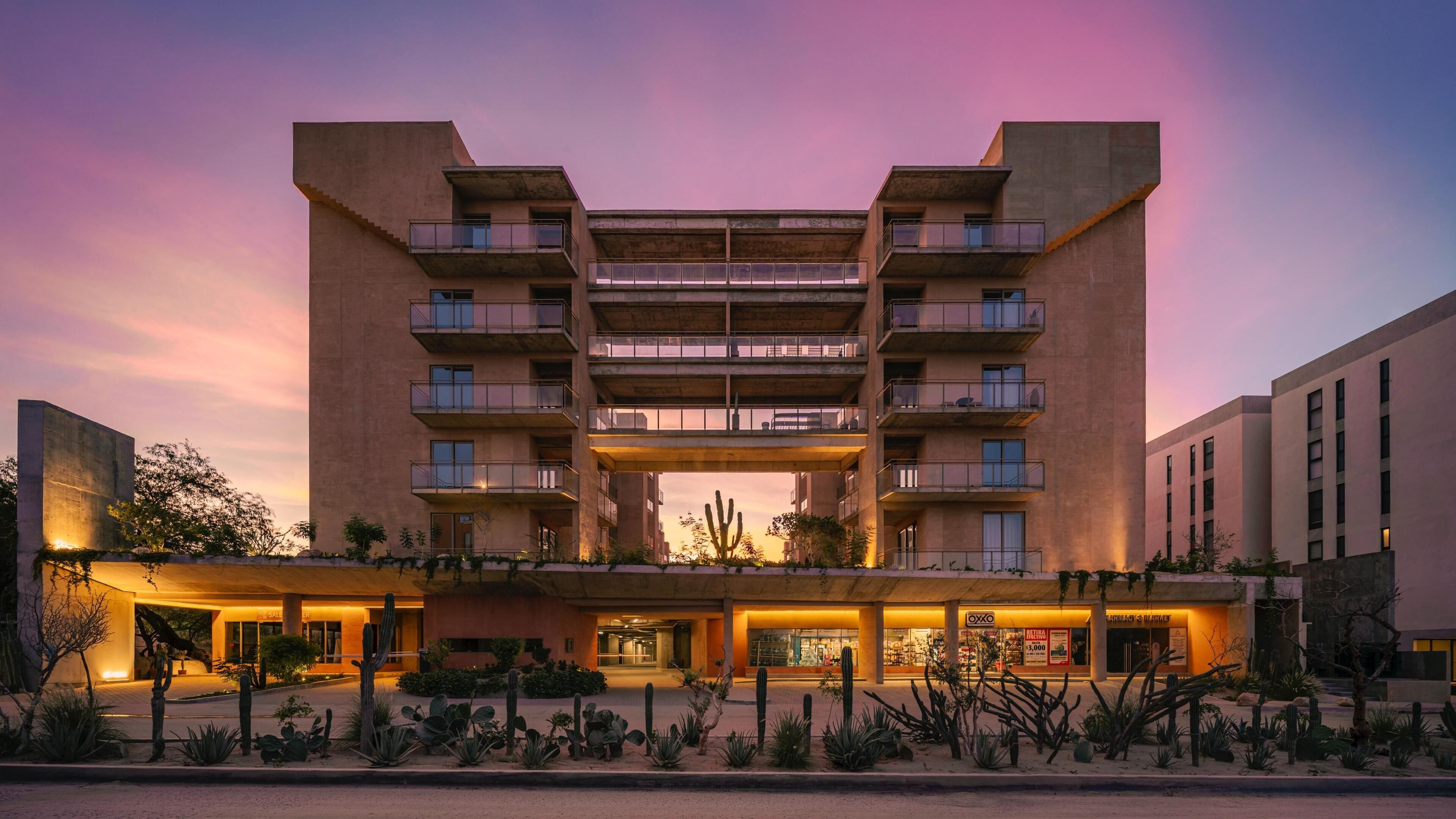 A multi-story hotel with a central atrium, balconies, and a desert garden with cacti.