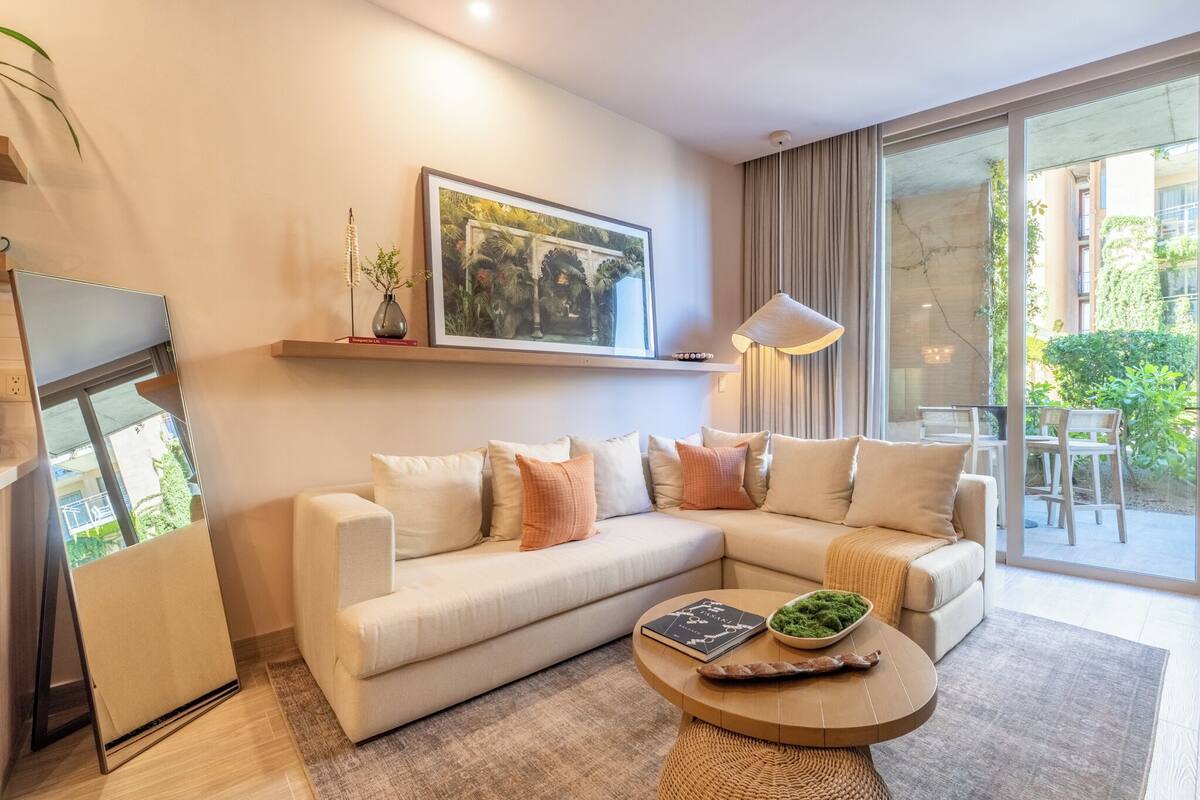 A modern living room with a sofa, a coffee table, a framed picture, and a lamp.