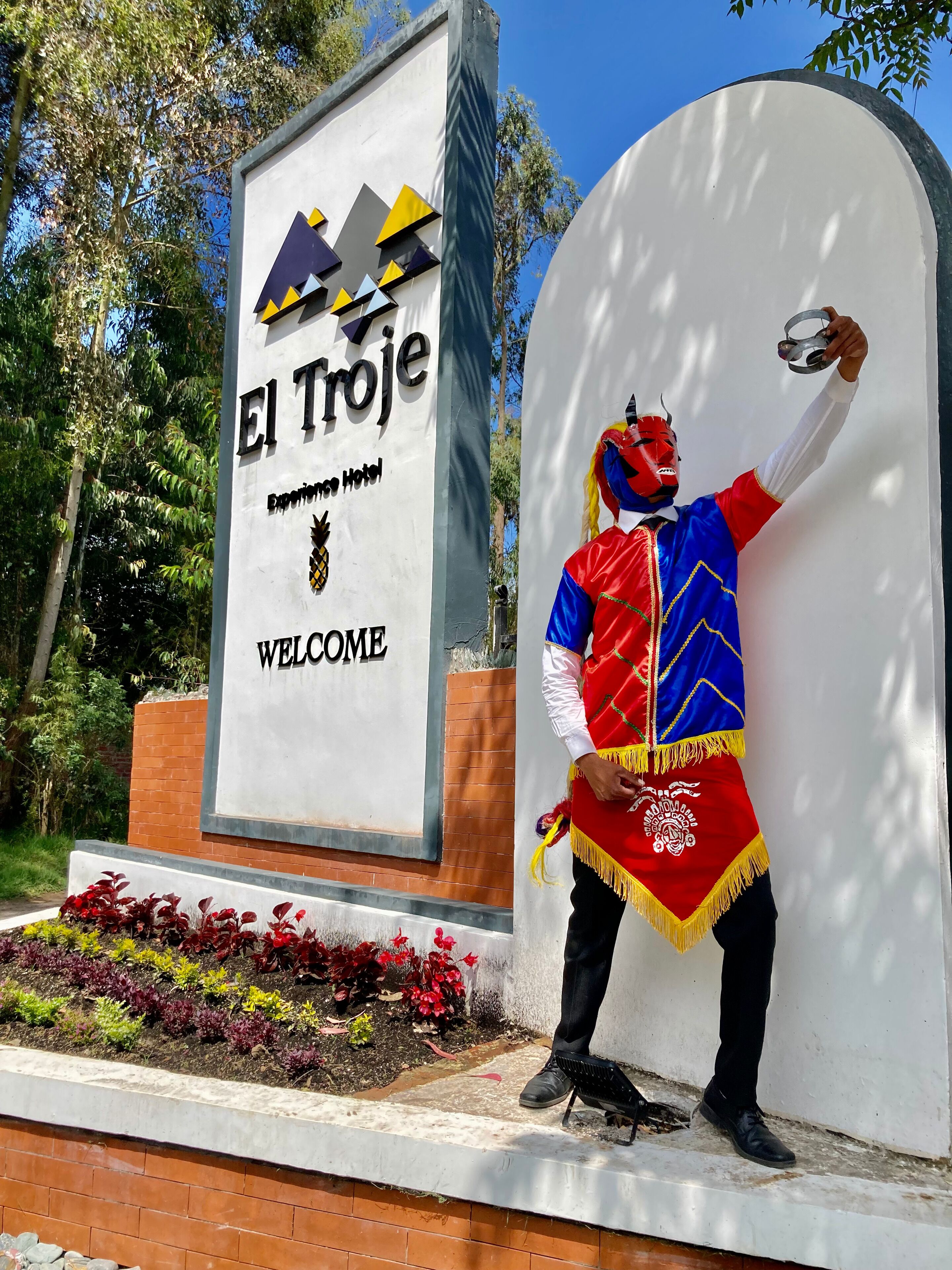 Placa de El Troje com mensagem de boas-vindas e uma figura decorativa.