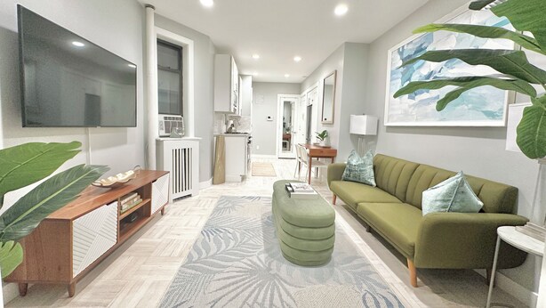 A modern living room with a sofa, a coffee table, and a TV.