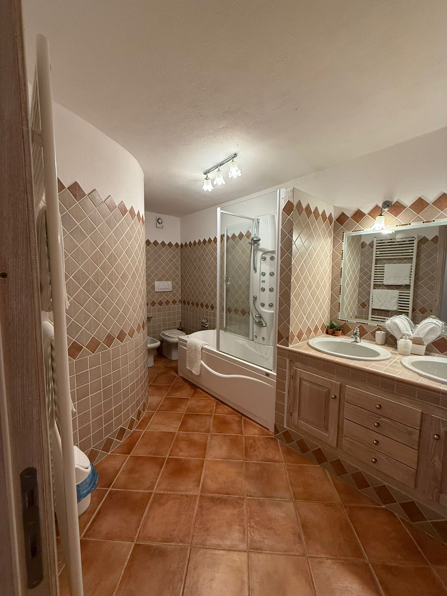 Ein Badezimmer mit Dusche, Toilette, Badewanne und Waschtisch mit Spiegel.