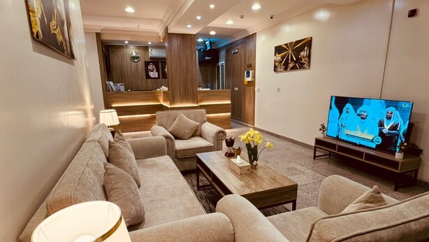 Una sala moderna con un conjunto de sofás, una mesa de centro y un televisor.