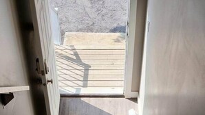 Una escalera que lleva a un espacio al aire libre con una terraza de madera.