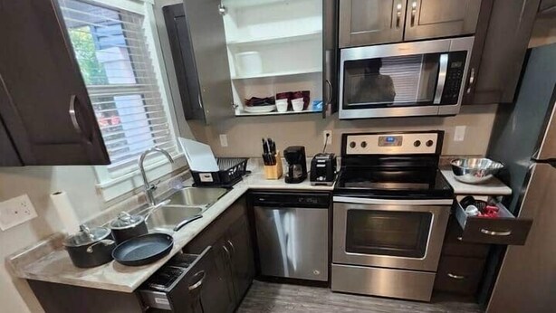 Una cocina moderna con electrodomésticos de acero inoxidable, armarios de madera y horno empotrado.