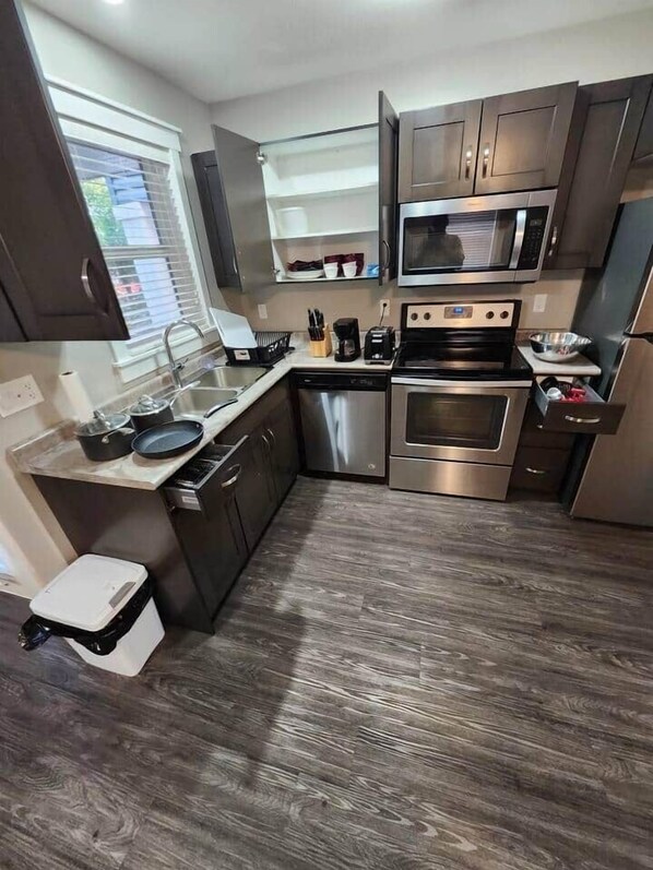 A modern kitchen with stainless steel appliances, wooden cabinets, and a built-in oven.