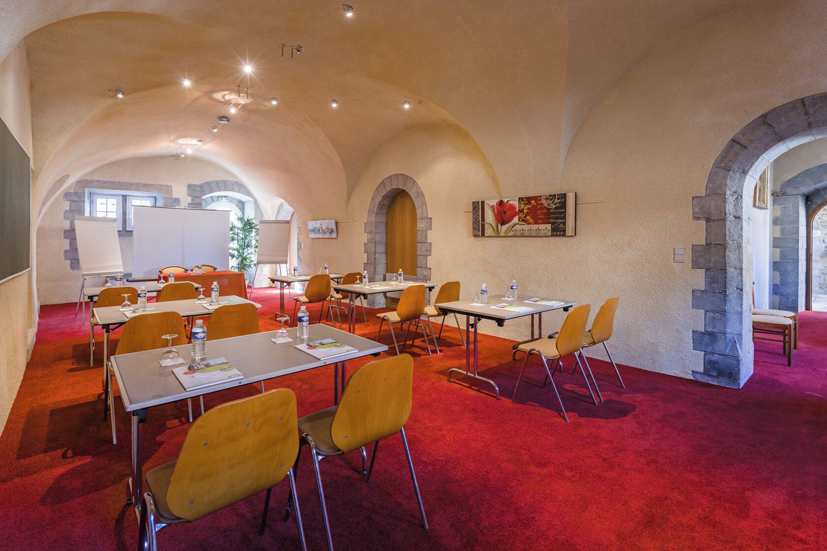A conference room with tables and chairs, a whiteboard, and a painting on the wall.