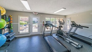 Un gimnasio con cintas de correr, pelotas de ejercicio y pesas.