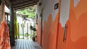 Una terraza de madera que conduce a un edificio de paredes anaranjadas y una puerta con la leyenda 'LUA'.