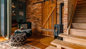A cozy room with a brick wall, a wooden staircase, a sofa, and a bench. - Cottage "Am Wald" links (Bissee)