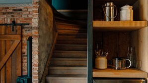 A staircase leading to a wooden door, a brick wall, and a shelf with kitchenware. - Cottage "Am Wald" links (Bissee)