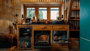 A compact kitchen with a built-in oven, a coffee machine, and a dishwasher.