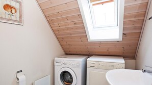 A small, compact laundry room with two washing machines and a sink. - 8 Person Holiday Home on a Holiday Park in Grasten (Grasten)
