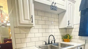 A kitchen with white cabinets, a double sink, and a marble countertop. - Two Bedroom House Close to Local Favorites (West Lafayette)