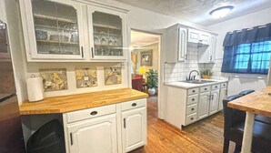 A kitchen with white cabinets, a wooden countertop, and a sink. - Two Bedroom House Close to Local Favorites (West Lafayette)