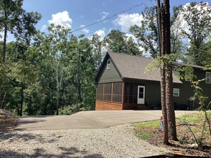 A two-story house with a large garage, surrounded by trees and a clear sky. - Brand new beautiful, quiet, and spacious 3-bedroom house next to Pickwick Lake (Counce)