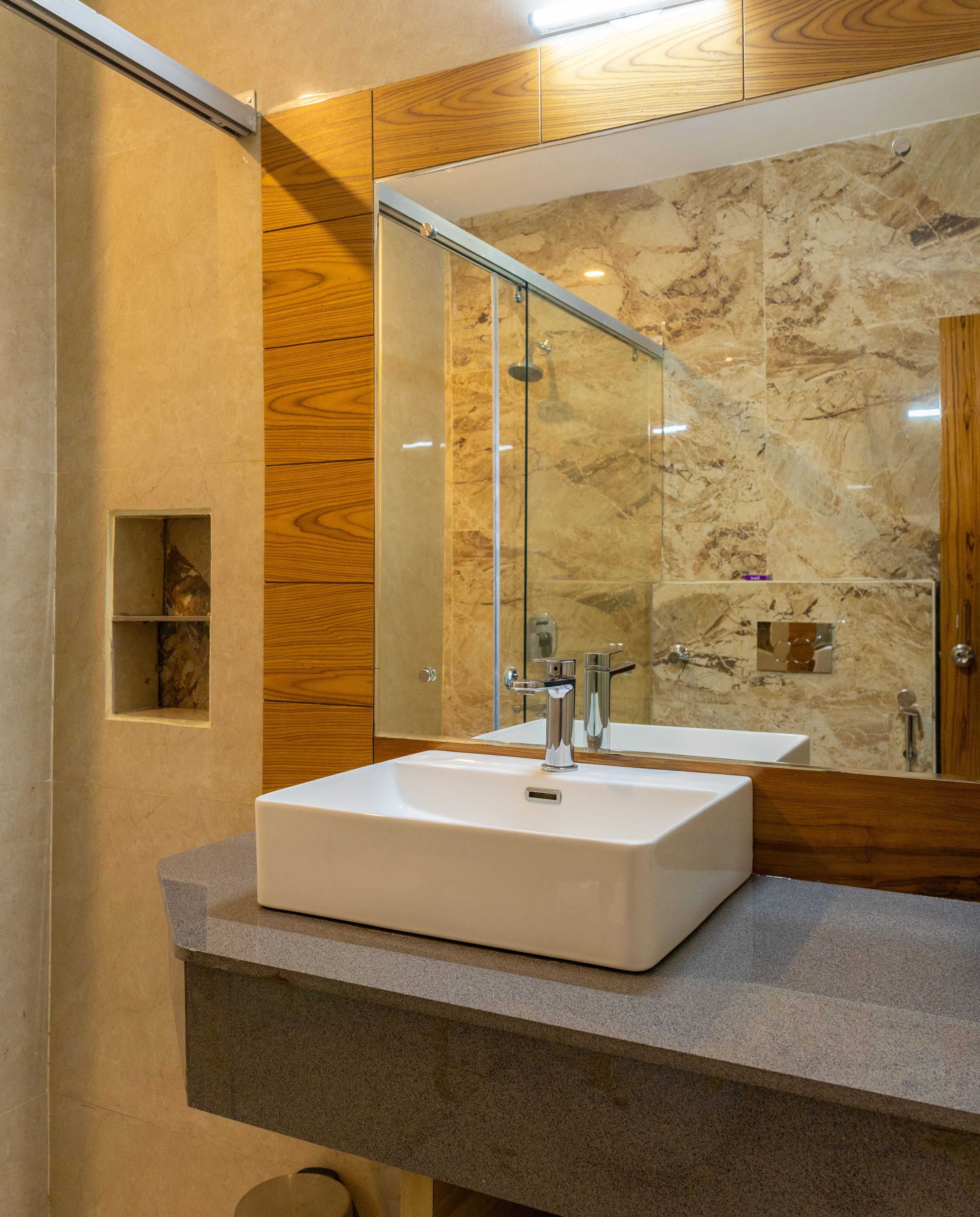 A bathroom with a white sink, a mirror, and wooden cabinets.