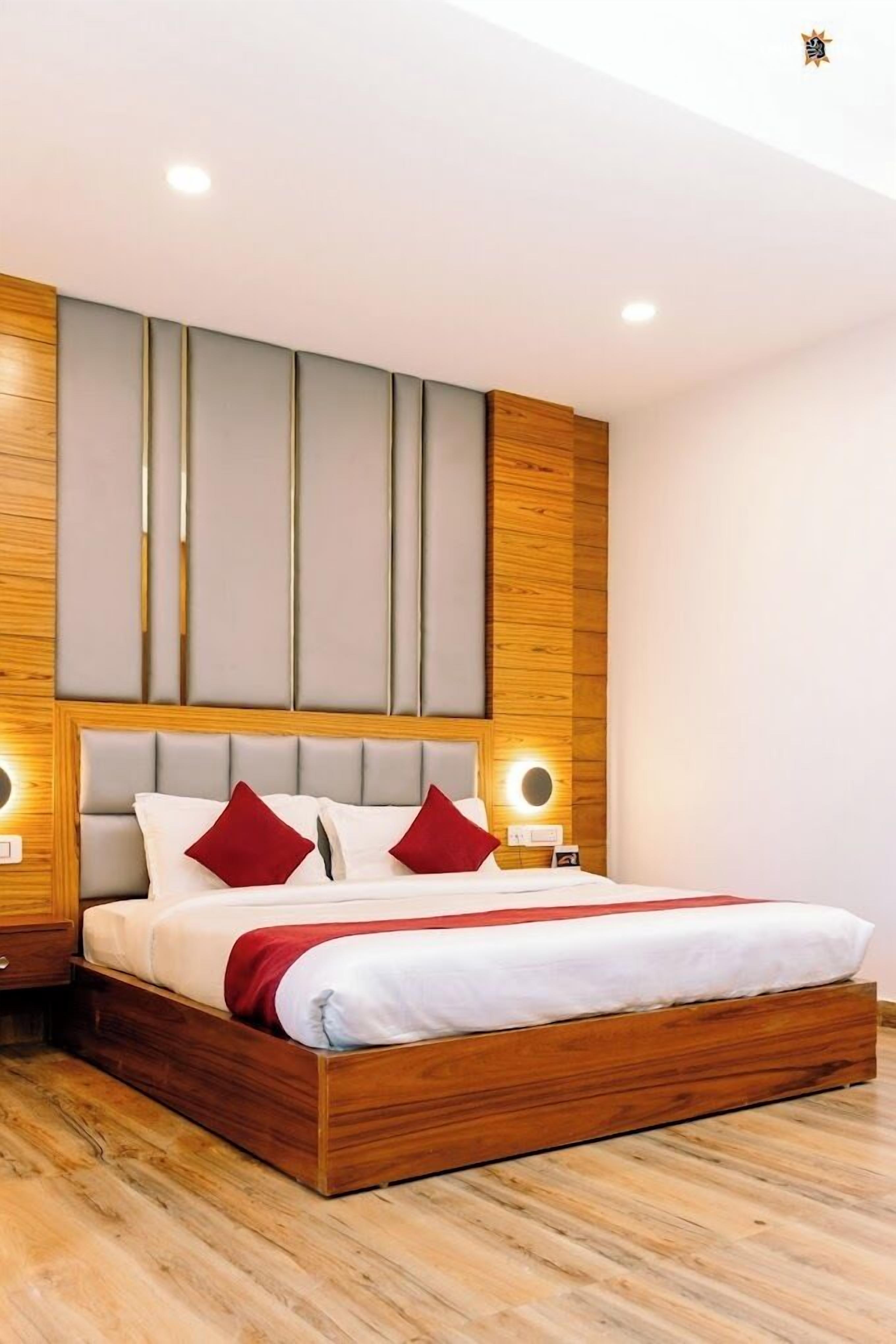 Une chambre à coucher moderne avec un cadre de lit en bois, une grande tête de lit et deux lampes de chevet.