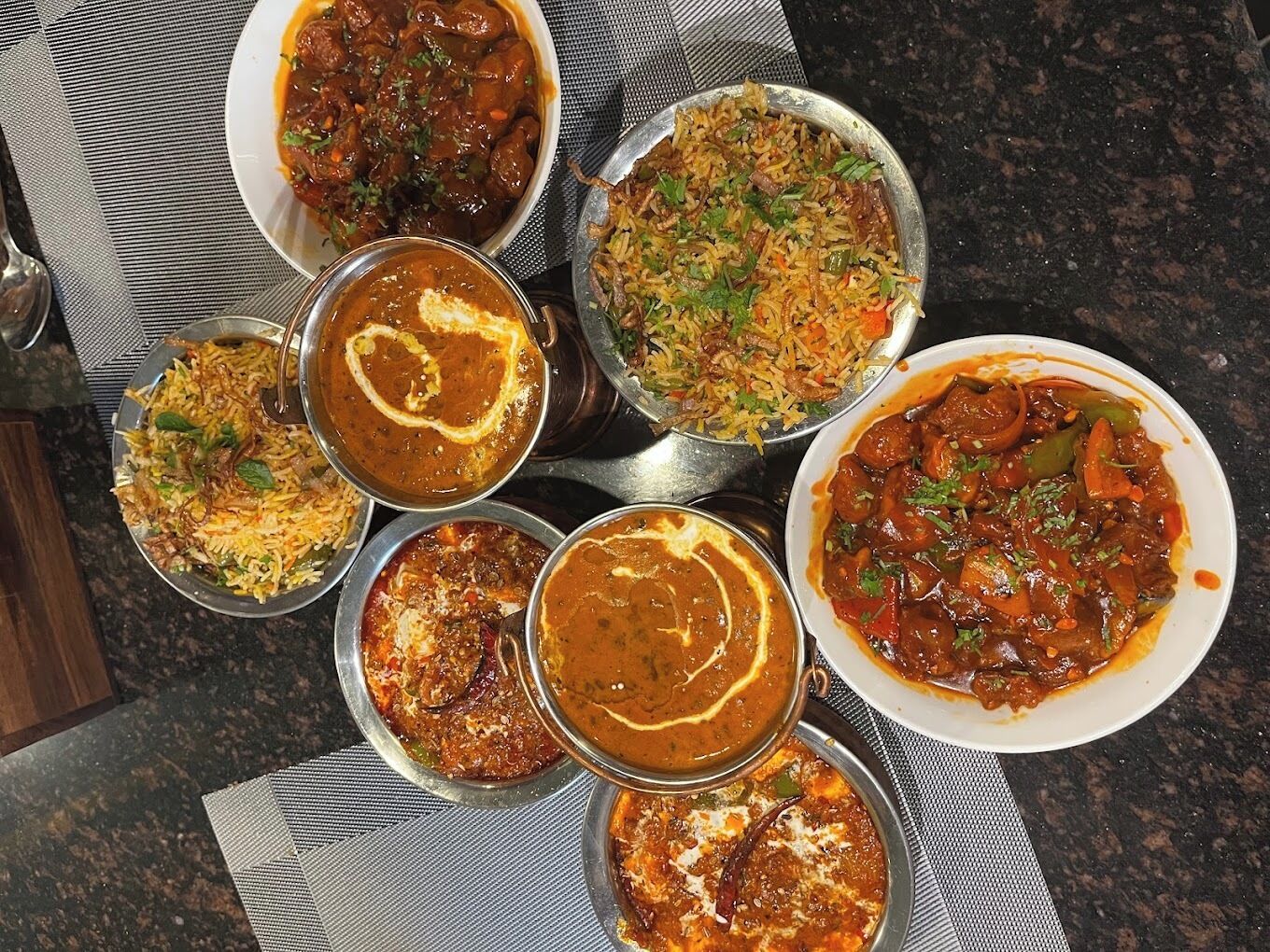 A variety of Indian dishes served on metal plates.