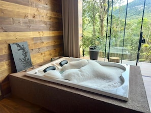 Eine Badewanne mit Blick auf eine üppige Landschaft.