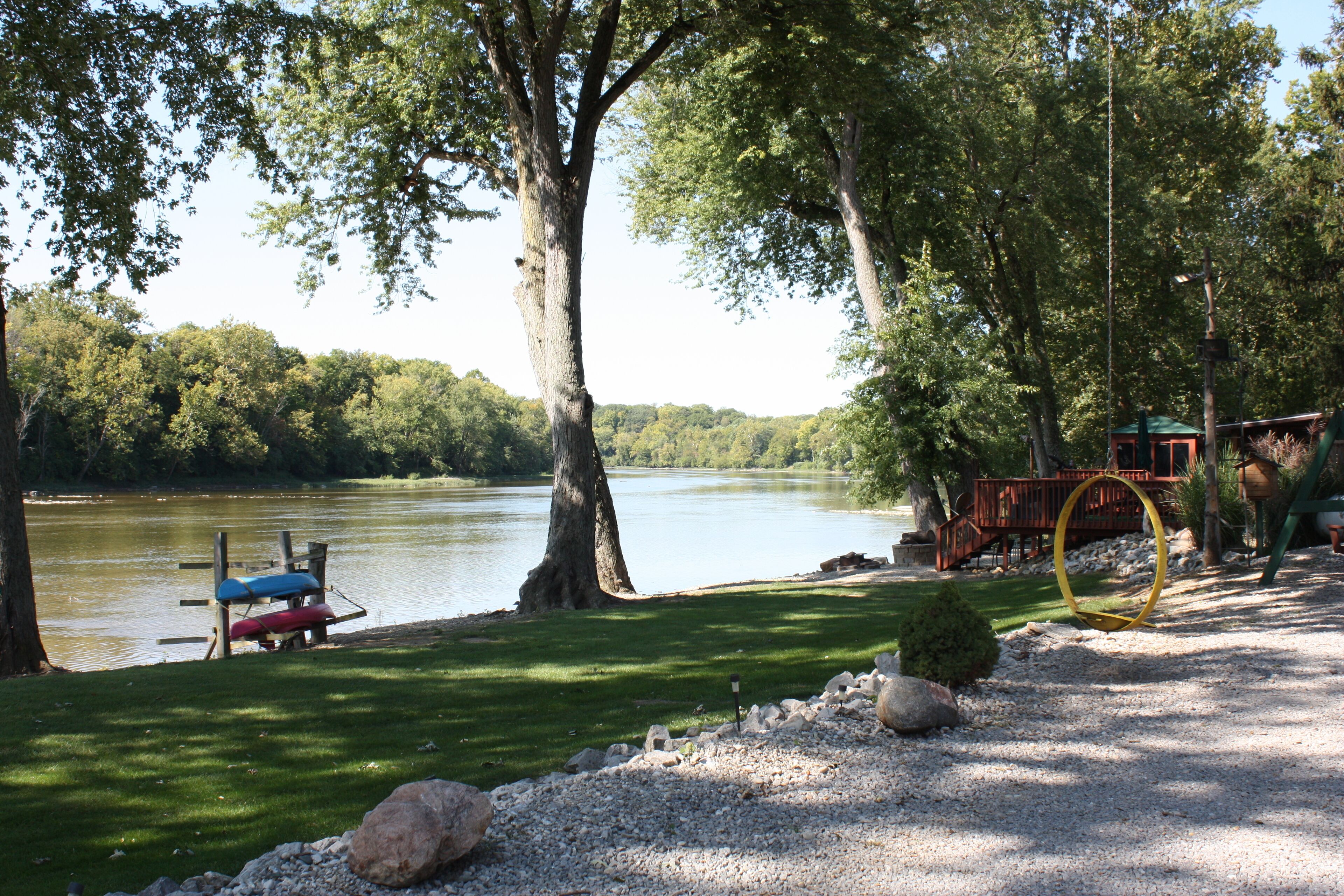 A lakeside park with a boat dock, a swing, and a gazebo.