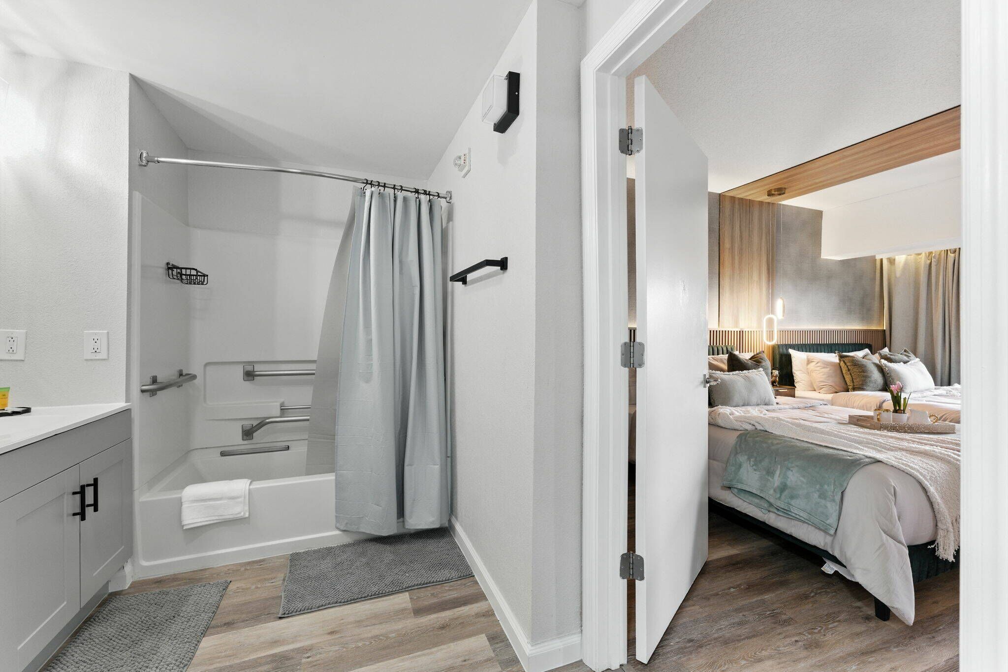 Une salle de bain moderne équipée d’une douche, de toilettes et d’un lavabo, ainsi qu’une chambre avec un lit et une table de chevet.