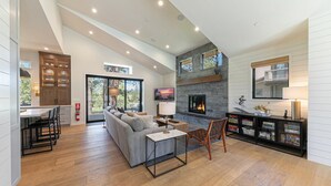 Un espacio habitable amplio con chimenea, un sofá y una mesa de comedor.